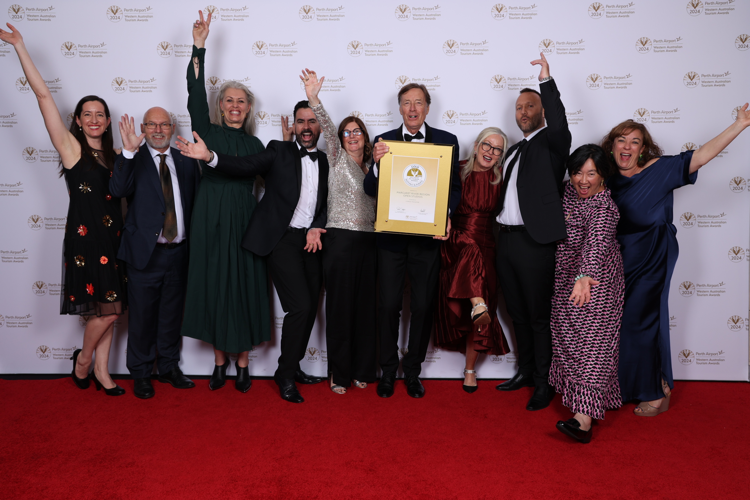 Group of happy people celebrating with an award certificate