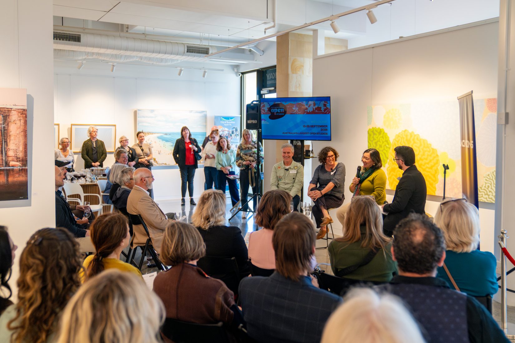 panel of people sitting in front of an audience in an art gallery